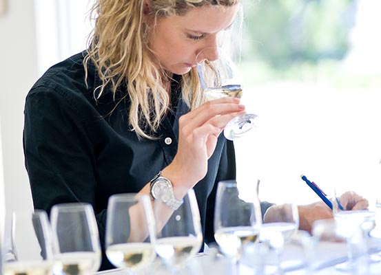 woman inspecting white wine